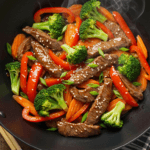 Beef stir fry recipe easy dinner with vegetables in a black wok on rustic table